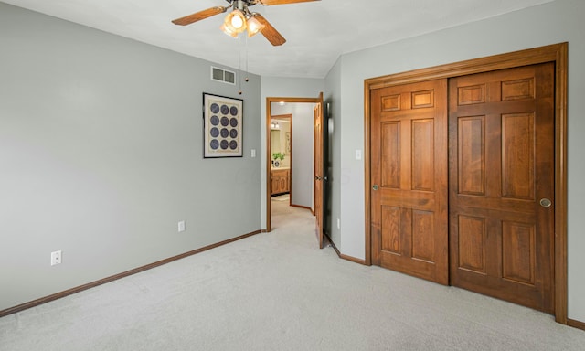 unfurnished bedroom featuring a closet, baseboards, visible vents, and light colored carpet