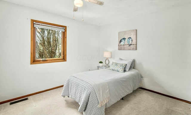 carpeted bedroom featuring baseboards, a ceiling fan, and visible vents