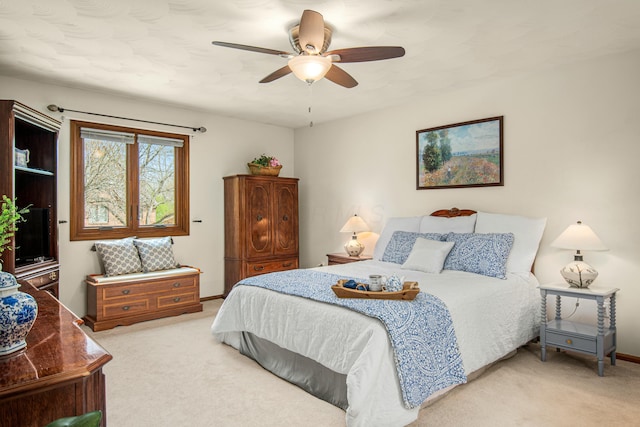 carpeted bedroom with a ceiling fan and baseboards