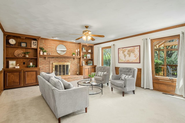 living area with a brick fireplace, a ceiling fan, light colored carpet, and ornamental molding