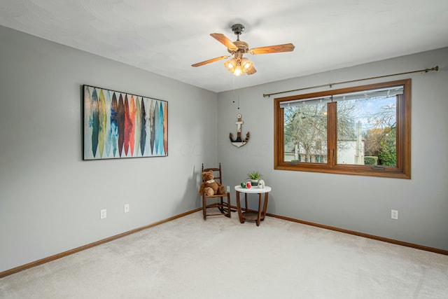 sitting room featuring baseboards, a ceiling fan, and carpet flooring