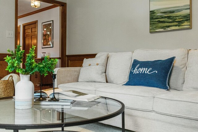 living room featuring crown molding and wainscoting