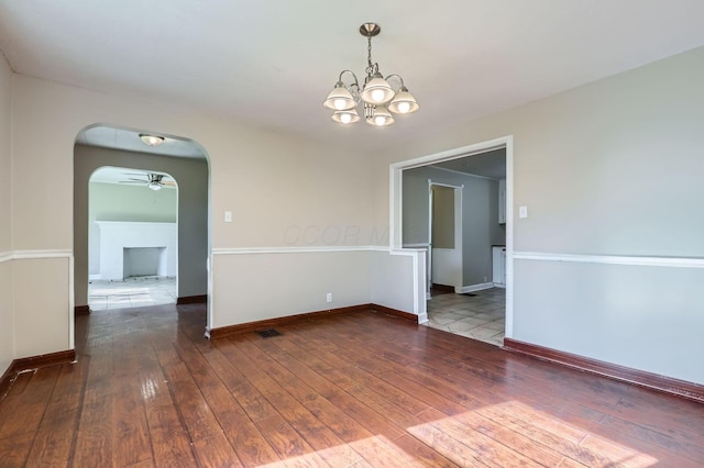 595 Collingwood Ave, Columbus, OH 43213 - empty room with an inviting chandelier, baseboards, arched walkways, and wood-type flooring