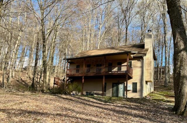 rear view of property featuring a chimney and a deck