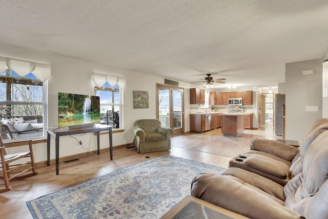 1649 Loudon St, Granville, OH 43023 - living area featuring a textured ceiling, ceiling fan, light wood-style flooring, baseboards, and visible vents