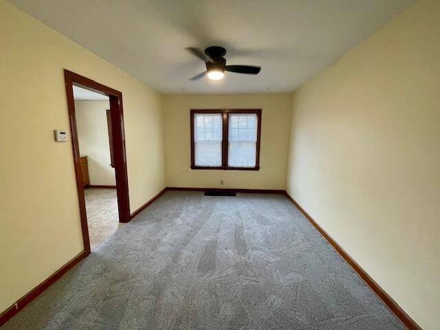 empty room with carpet, ceiling fan, and baseboards