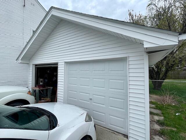 detached garage featuring washer / clothes dryer and fence