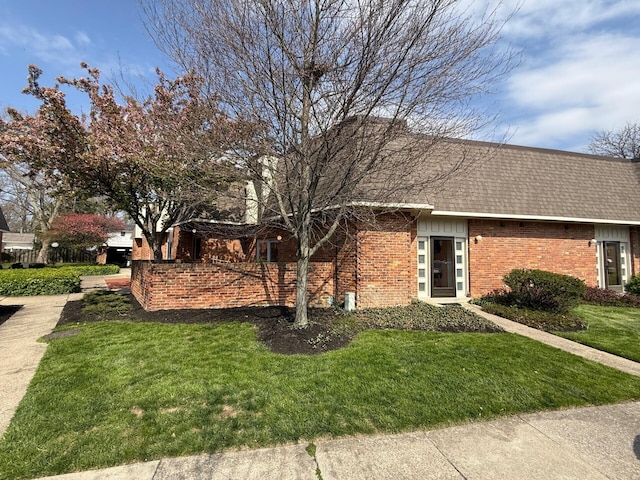 1610 Lafayette Dr Unit 1610, Columbus, OH 43220 - view of side of property featuring brick siding, a lawn, and a shingled roof