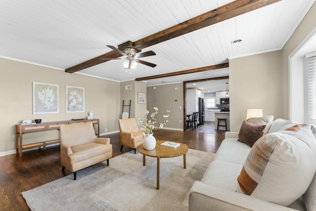 living area featuring wood finished floors, a ceiling fan, beam ceiling, crown molding, and baseboards
