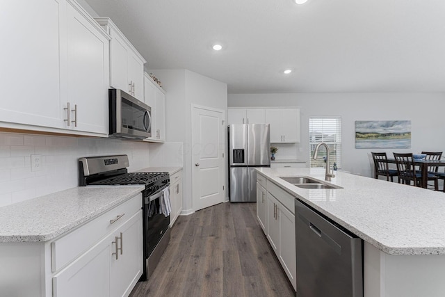 kitchen with tasteful backsplash, dark wood-style flooring, white cabinets, stainless steel appliances, and a sink