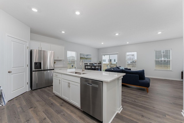 kitchen featuring appliances with stainless steel finishes, dark wood-style flooring, a sink, and white cabinetry