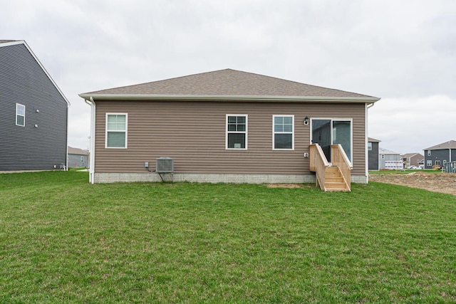 rear view of house featuring a yard and central air condition unit