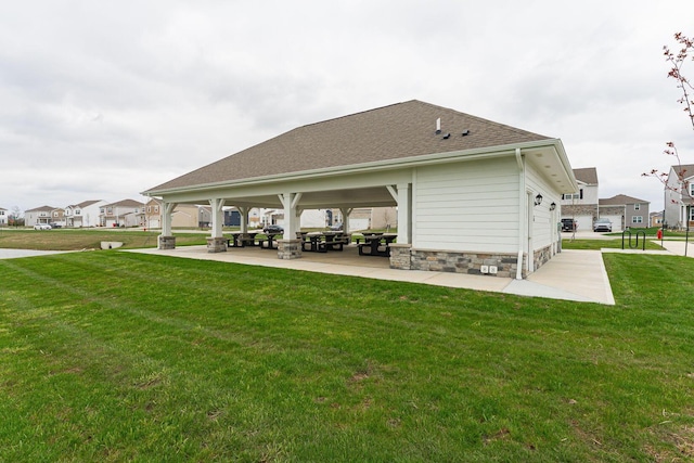 rear view of property featuring a yard and a shingled roof