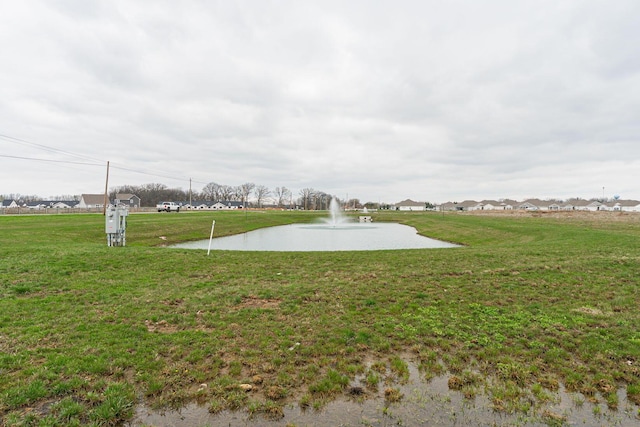 view of property's community with a water view and a yard
