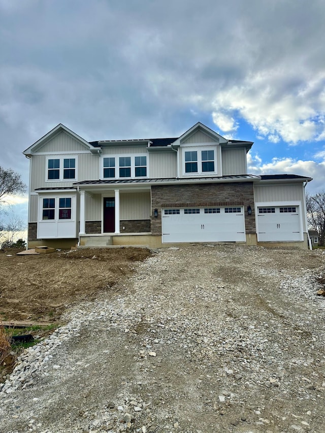 view of front of house with a porch, dirt driveway, and a garage