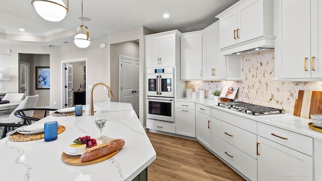 kitchen featuring stainless steel gas cooktop, a sink, white cabinetry, backsplash, and white double oven