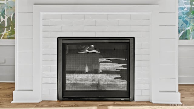 room details with a glass covered fireplace and wood finished floors