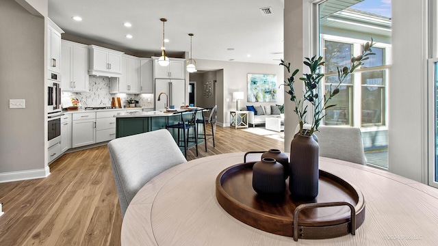 dining room featuring recessed lighting, light wood-style flooring, visible vents, and baseboards