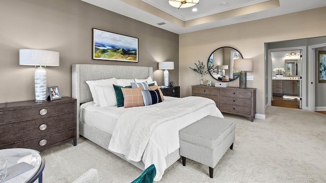bedroom featuring a tray ceiling, light carpet, connected bathroom, crown molding, and baseboards