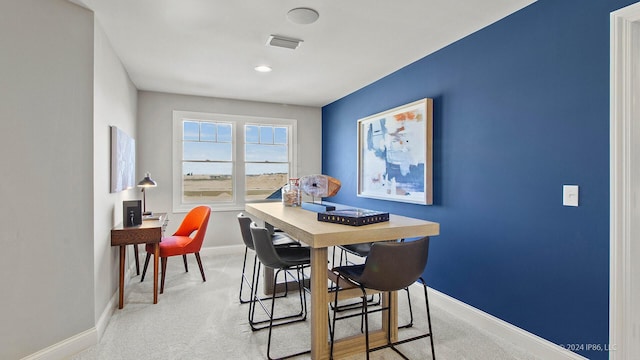 dining area featuring visible vents, baseboards, and light carpet