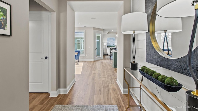 corridor featuring light wood finished floors, baseboards, and recessed lighting