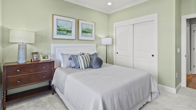 bedroom featuring baseboards, ornamental molding, carpet flooring, and a closet