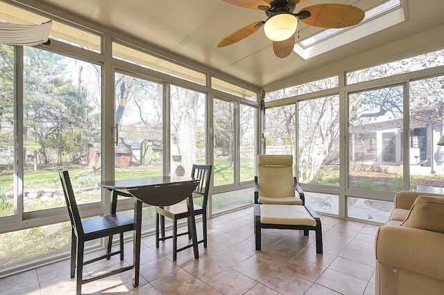 sunroom featuring a wall of windows, a ceiling fan, and tile patterned flooring