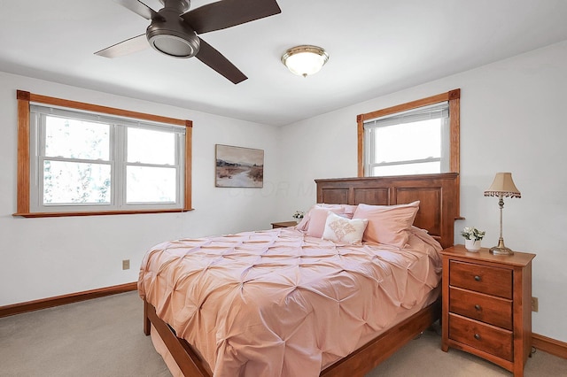 bedroom with multiple windows, light colored carpet, and baseboards