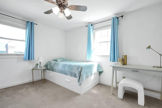 bedroom featuring light colored carpet, baseboards, and ceiling fan