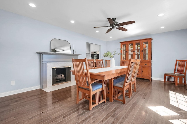 dining space with baseboards, a ceiling fan, and wood finished floors