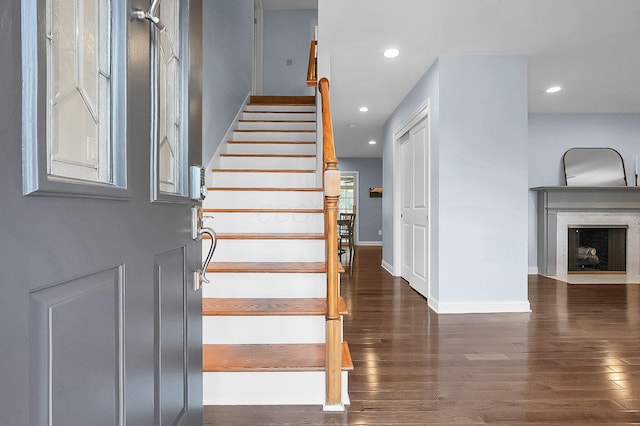 stairway with recessed lighting, a fireplace, baseboards, and wood finished floors