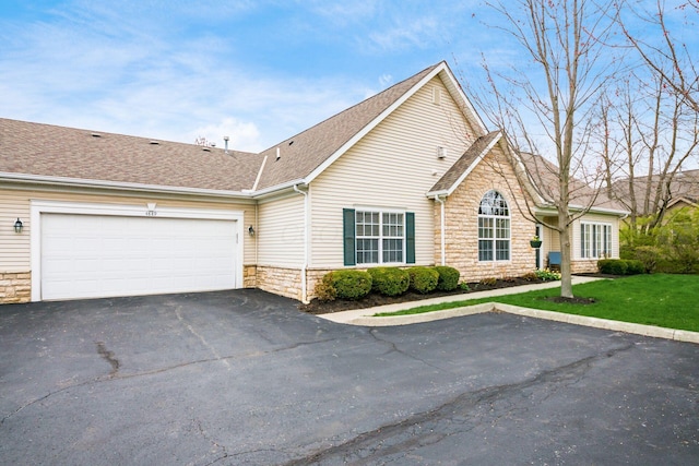 4889 Ashleigh Dr, Dublin, OH 43016 - single story home featuring driveway, stone siding, an attached garage, a front lawn, and a shingled roof
