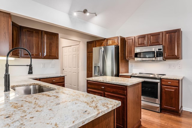 4889 Ashleigh Dr, Dublin, OH 43016 - kitchen with light wood-style floors, vaulted ceiling, appliances with stainless steel finishes, light stone counters, and a sink