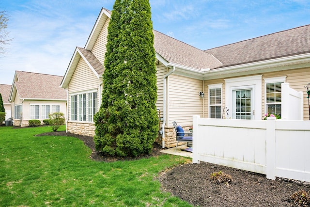 4889 Ashleigh Dr, Dublin, OH 43016 - view of property exterior featuring roof with shingles, fence, and a lawn