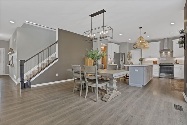 dining space featuring light wood-style floors, visible vents, recessed lighting, stairway, and a notable chandelier