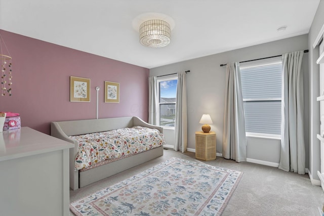 bedroom with light colored carpet and baseboards