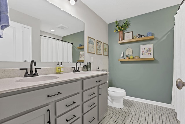 full bath with toilet, double vanity, a sink, and visible vents