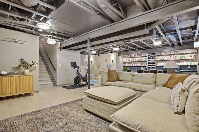 living area featuring a bar, stairway, and wood finished floors