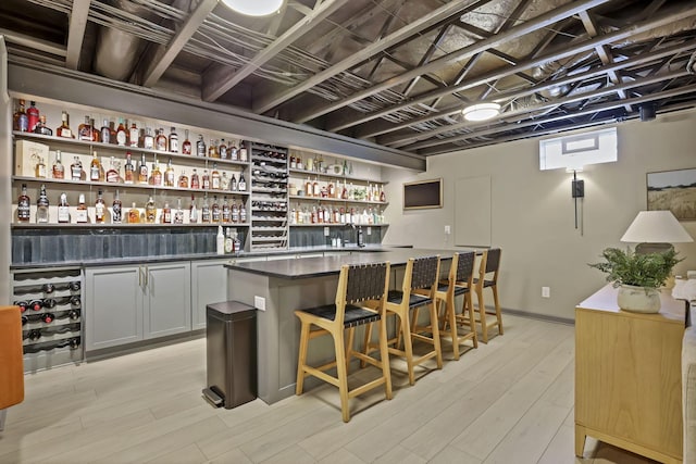 bar featuring light wood-type flooring and a dry bar