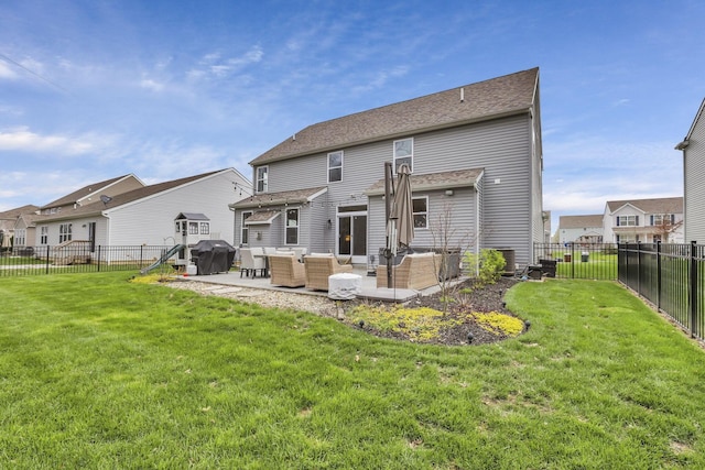 rear view of house featuring outdoor lounge area, a patio area, a fenced backyard, and a lawn
