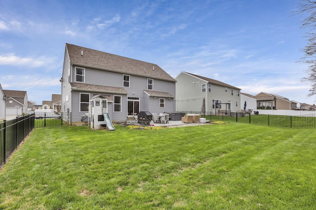 back of property with a yard, a fenced backyard, a residential view, and a patio