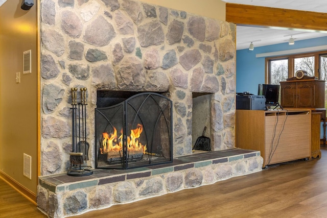 8778 Township Rd 36, Somerset, OH 43783 - details with visible vents, a stone fireplace, beamed ceiling, and wood finished floors