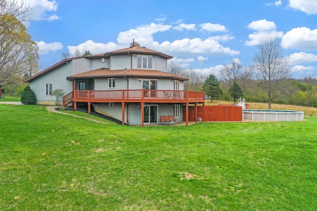 8778 Township Rd 36, Somerset, OH 43783 - rear view of house with a chimney, a lawn, an outdoor pool, a wooden deck, and a shingled roof