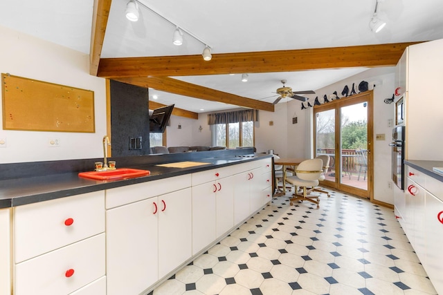 8778 Township Rd 36, Somerset, OH 43783 - kitchen featuring rail lighting, dark countertops, beam ceiling, light floors, and a sink