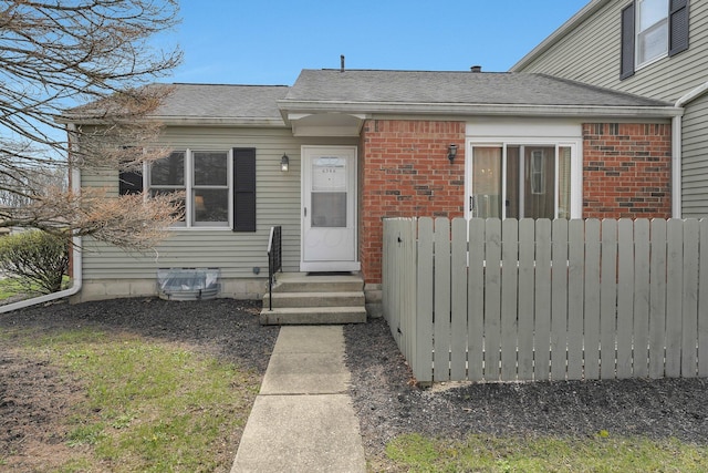6346 Well Fleet Dr Unit 96, Columbus, OH 43231 - view of front facade featuring brick siding, fence, and a shingled roof