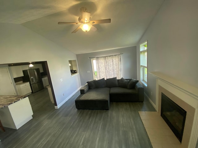 living area with a fireplace with flush hearth, baseboards, dark wood finished floors, and lofted ceiling