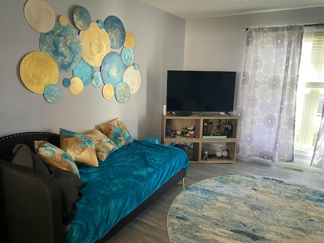 bedroom featuring wood finished floors and visible vents