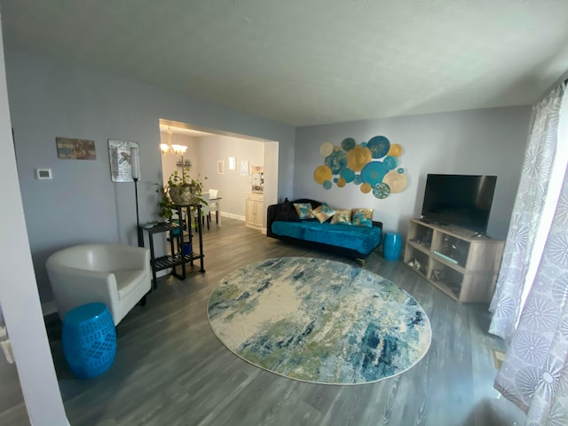 living area featuring baseboards, an inviting chandelier, and wood finished floors