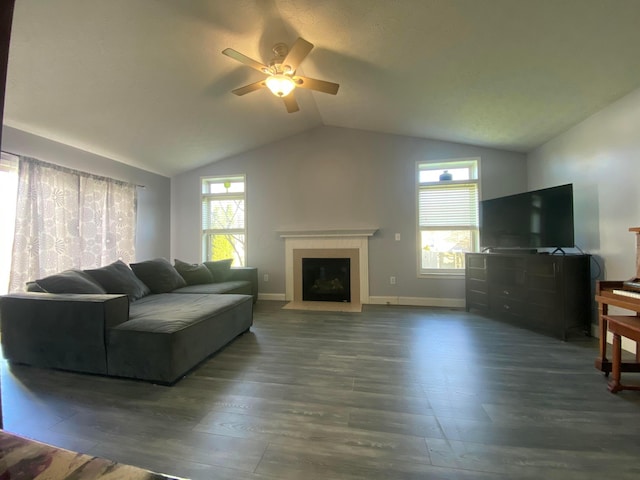 living area featuring lofted ceiling, baseboards, wood finished floors, and ceiling fan