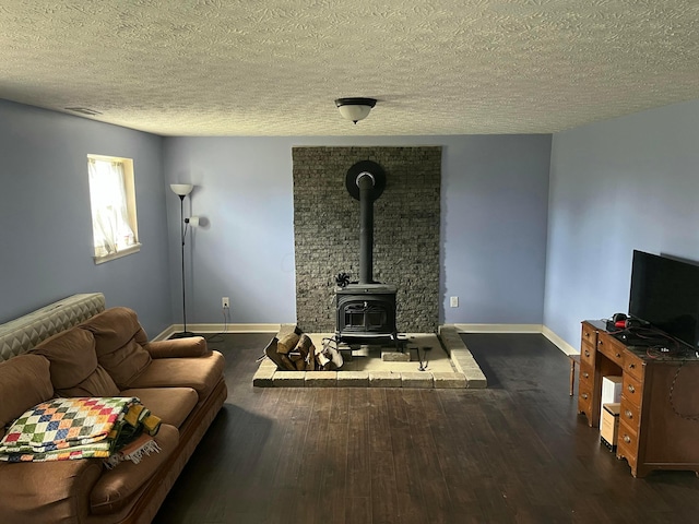 living room with dark wood finished floors, a wood stove, baseboards, and a textured ceiling